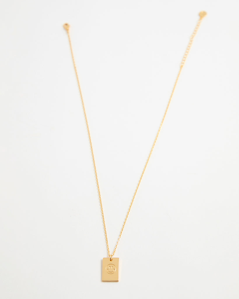 Gold necklace with smiley face pendant