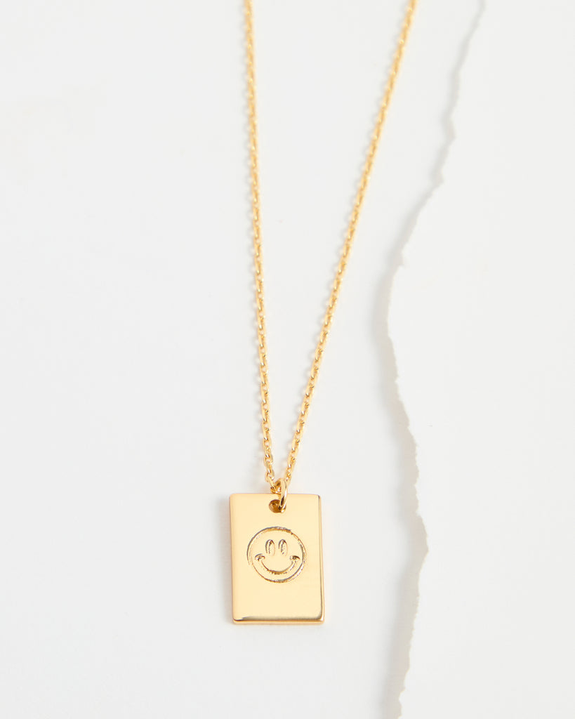 Gold necklace with smiley face pendant