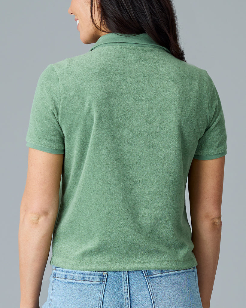 Woman in a green, short sleeve, collared terry cloth top