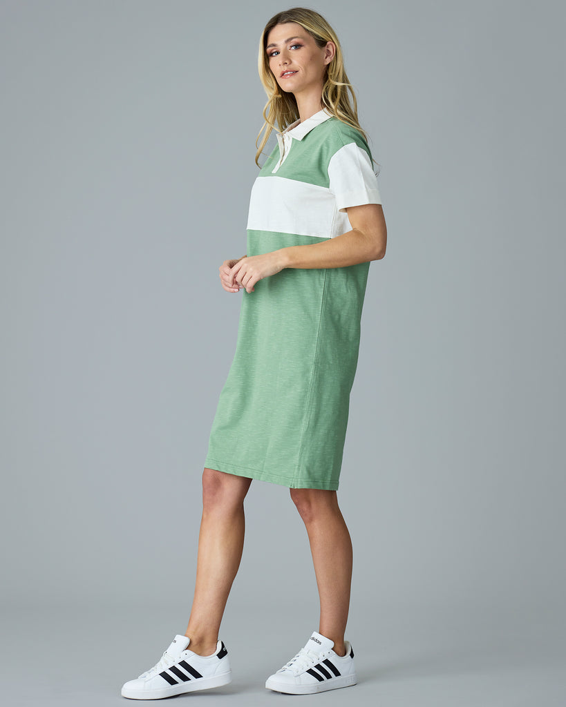 Woman in a green, short sleeve dress with collar