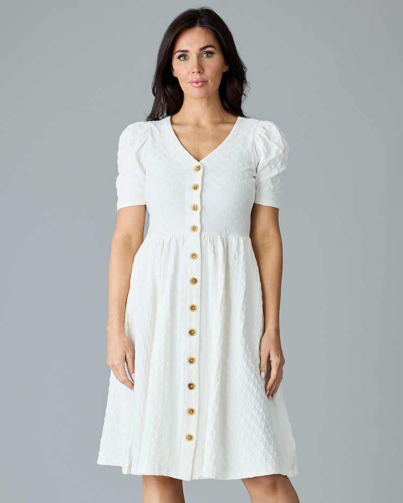 Woman in a white, short sleeve, v-neck dress