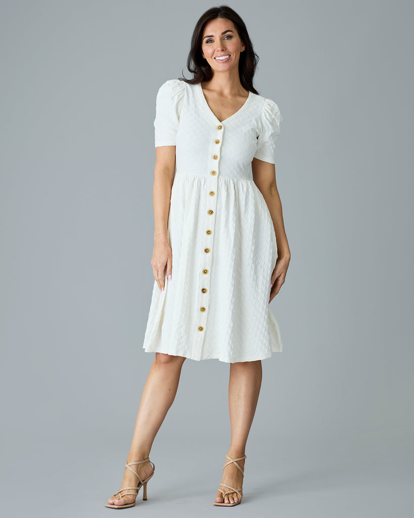 Woman in a white, short sleeve, v-neck dress