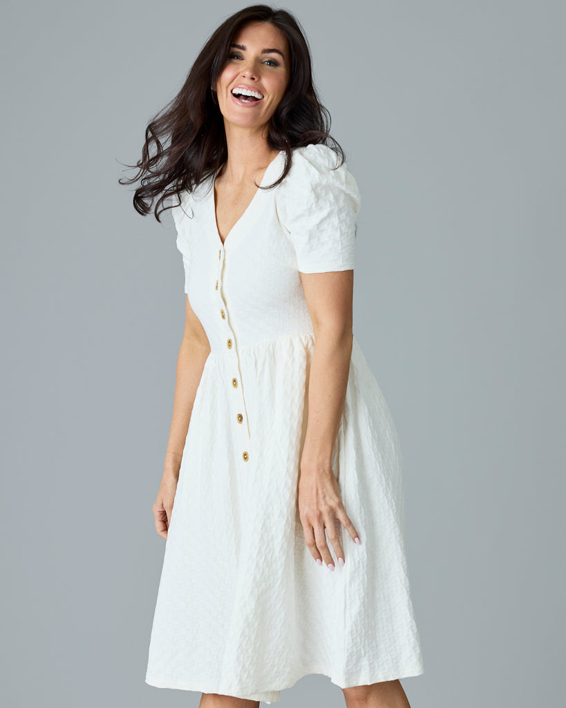 Woman in a white, short sleeve, v-neck dress