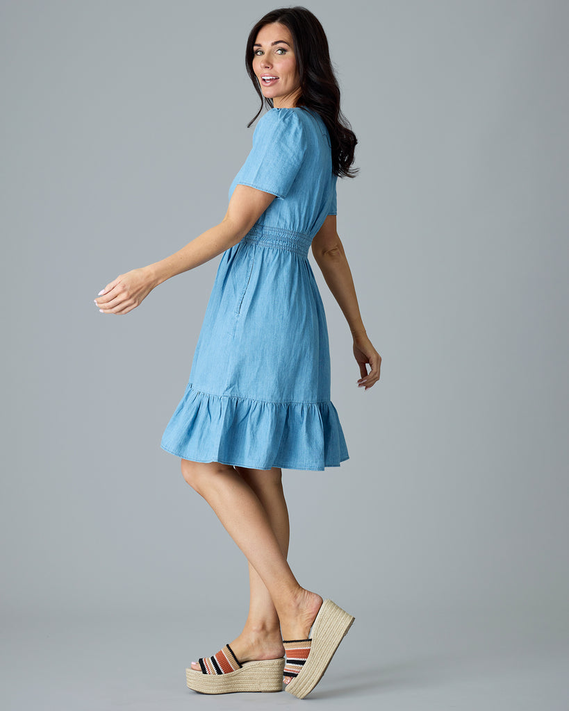 Woman in a light blue chambray, short sleeve, knee length dress