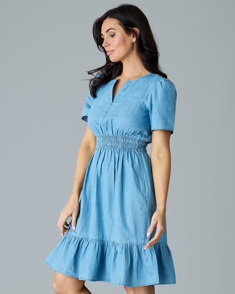 Woman in a light blue chambray, short sleeve, knee length dress