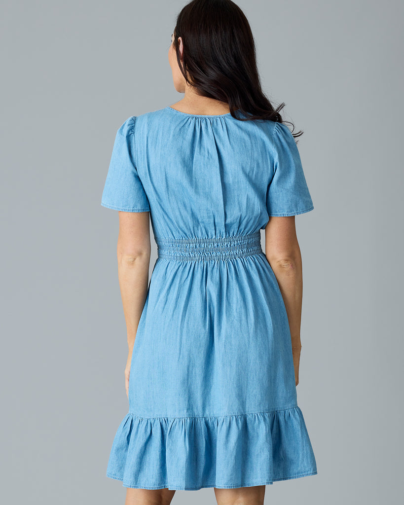 Woman in a light blue chambray, short sleeve, knee length dress