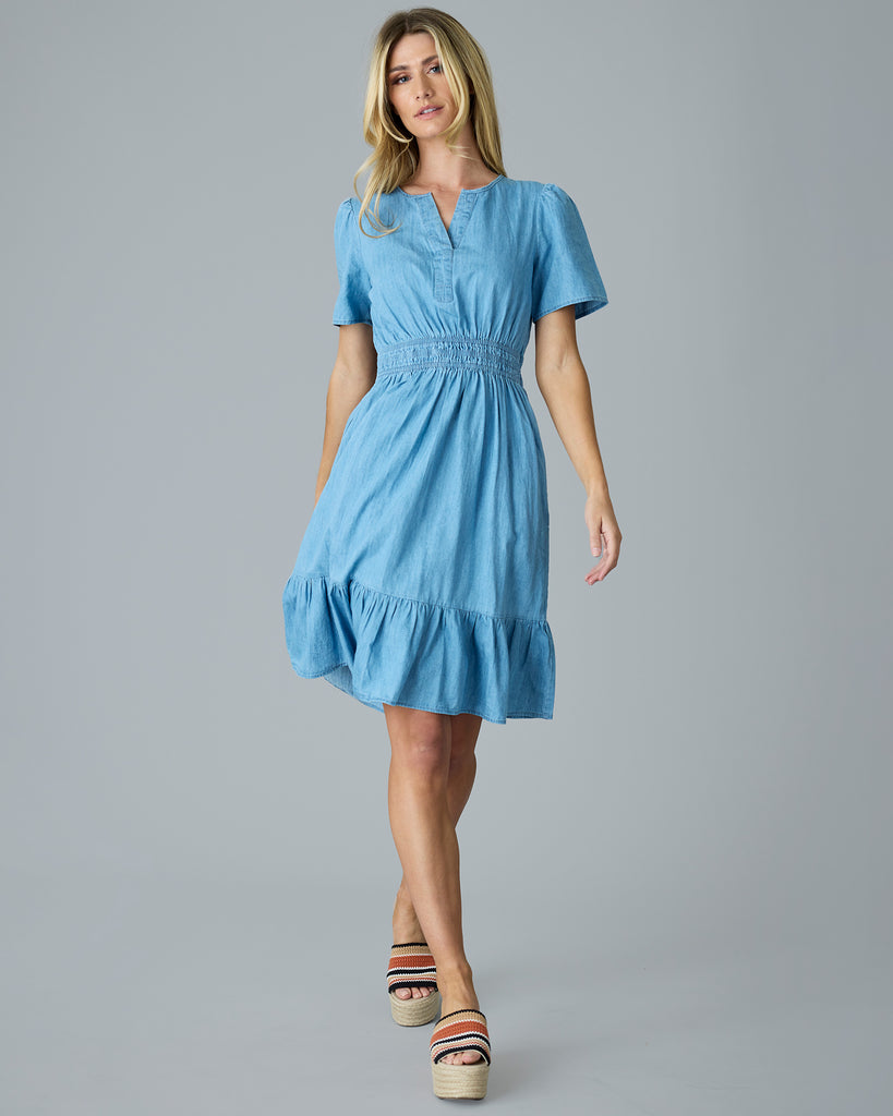 Woman in a light blue chambray, short sleeve, knee length dress