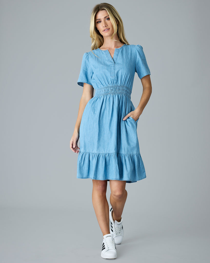 Woman in a light blue chambray, short sleeve, knee length dress