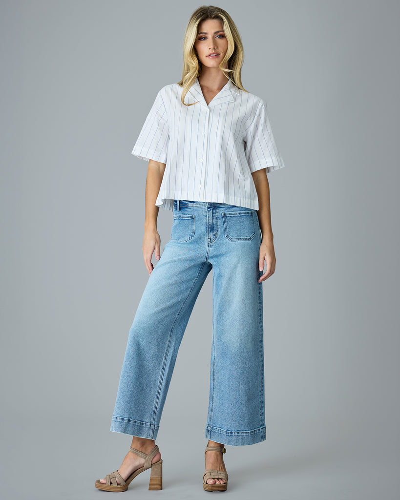 Woman in a white with blue vertical stripes, short sleeve buttondown