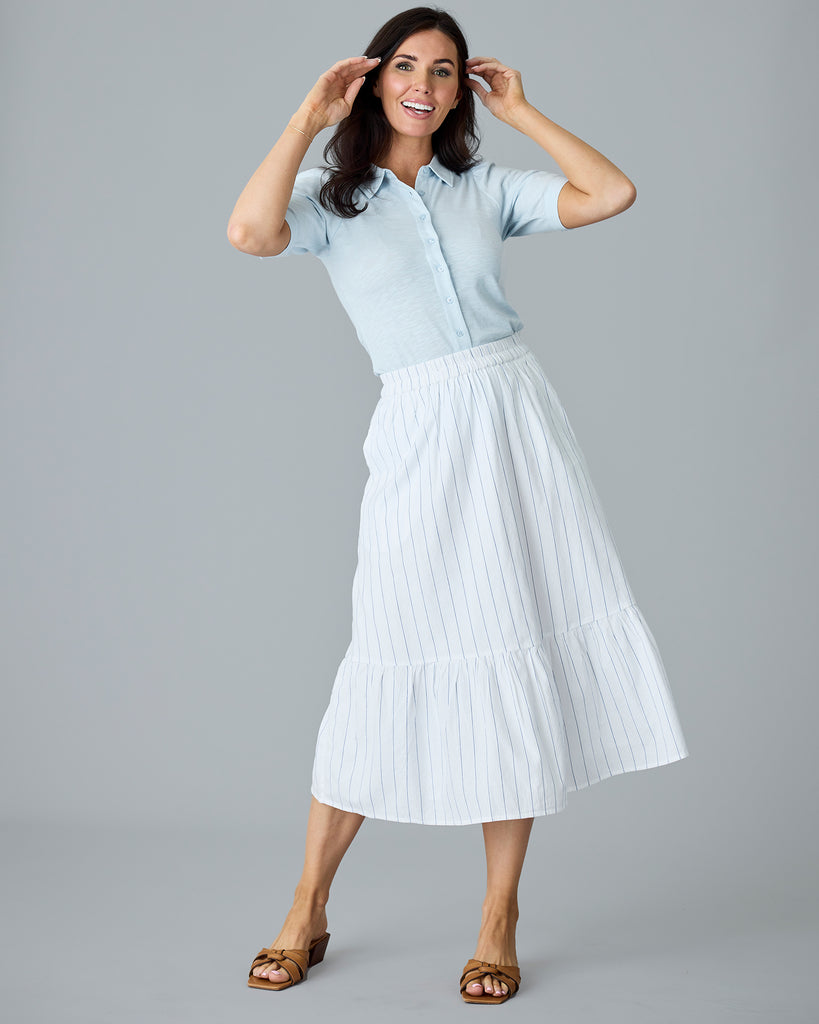 Woman in a white with blue vertical stripes midi length skirt