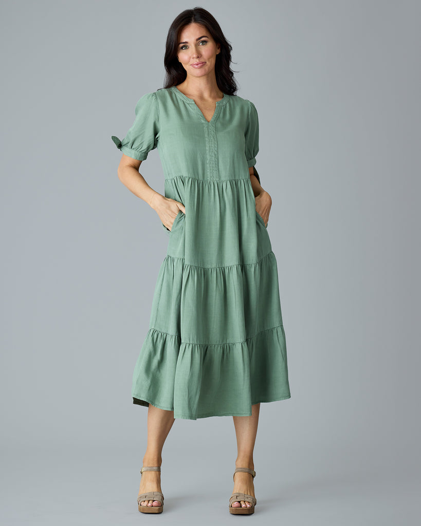 Woman in a green short sleeve midi length dress