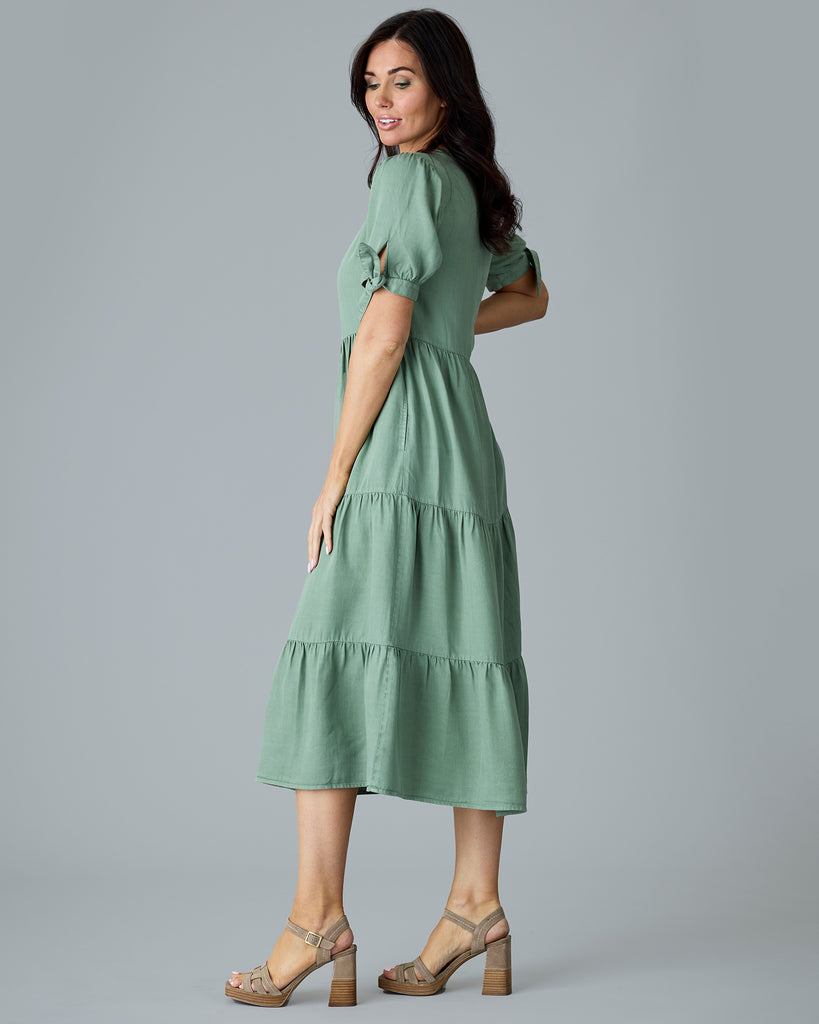 Woman in a green short sleeve midi length dress