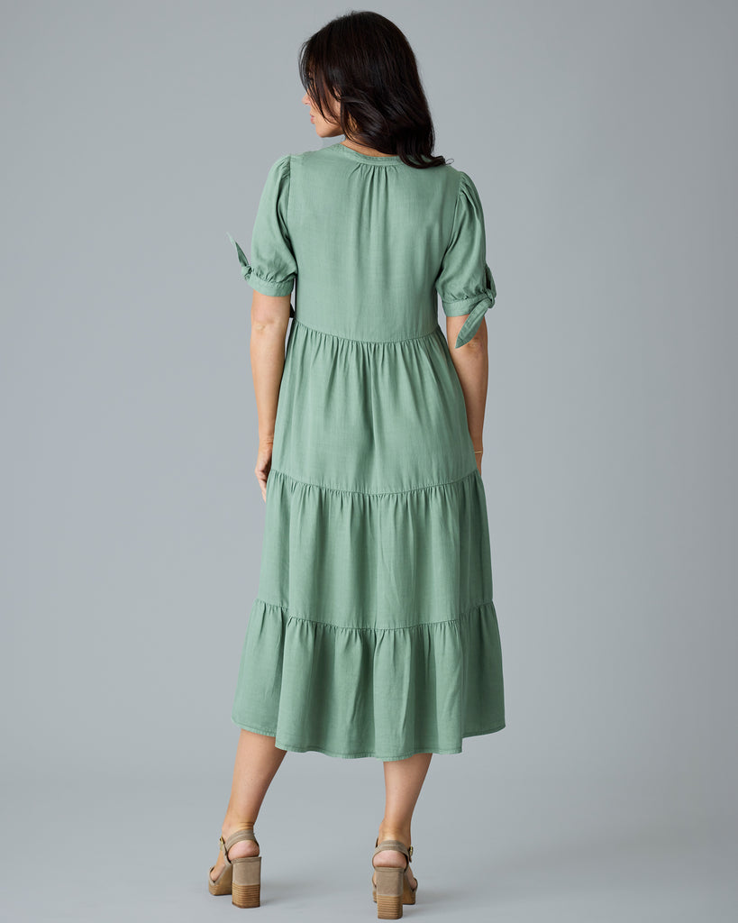 Woman in a green short sleeve midi length dress