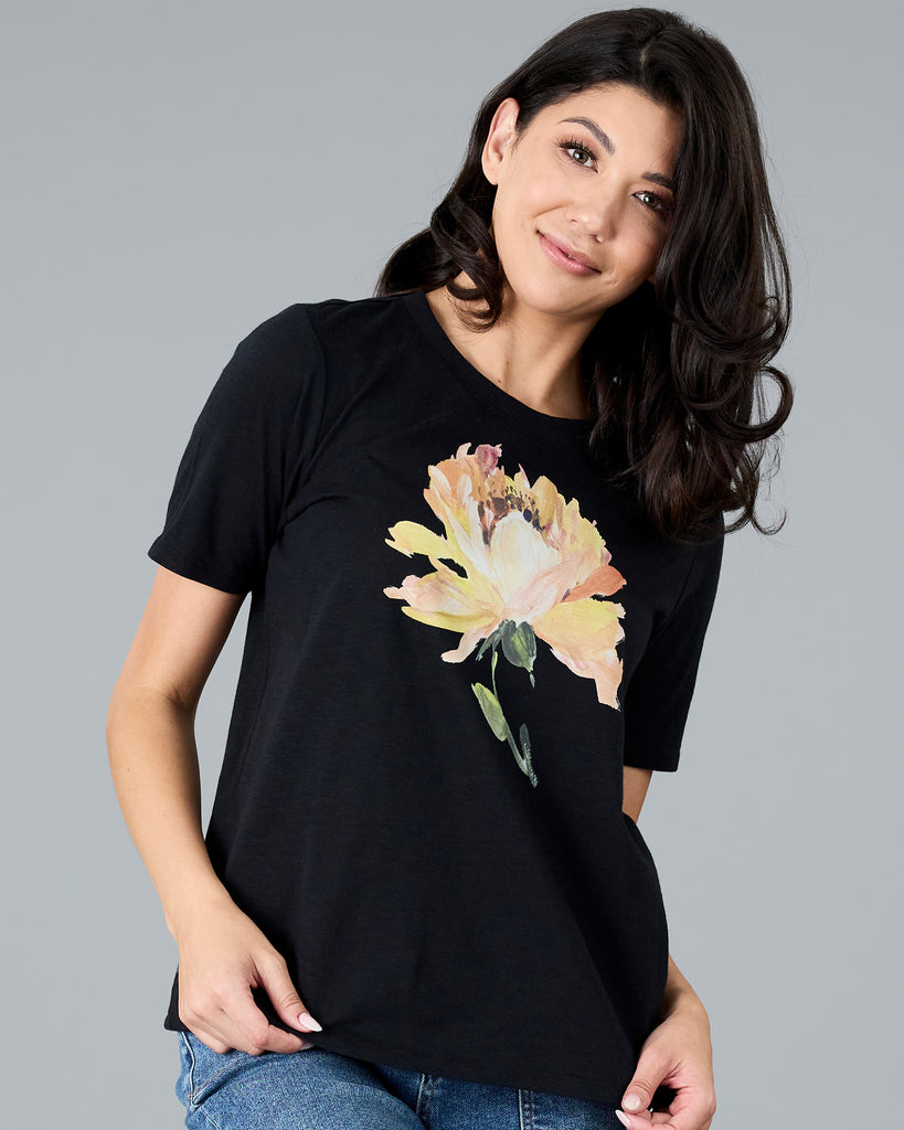 Woman in a black short sleeve tee with floral graphic design