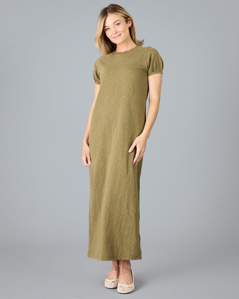 Woman in a short sleeve olive green sheath dress