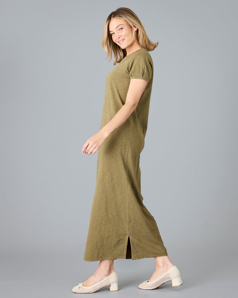 Woman in a short sleeve olive green sheath dress