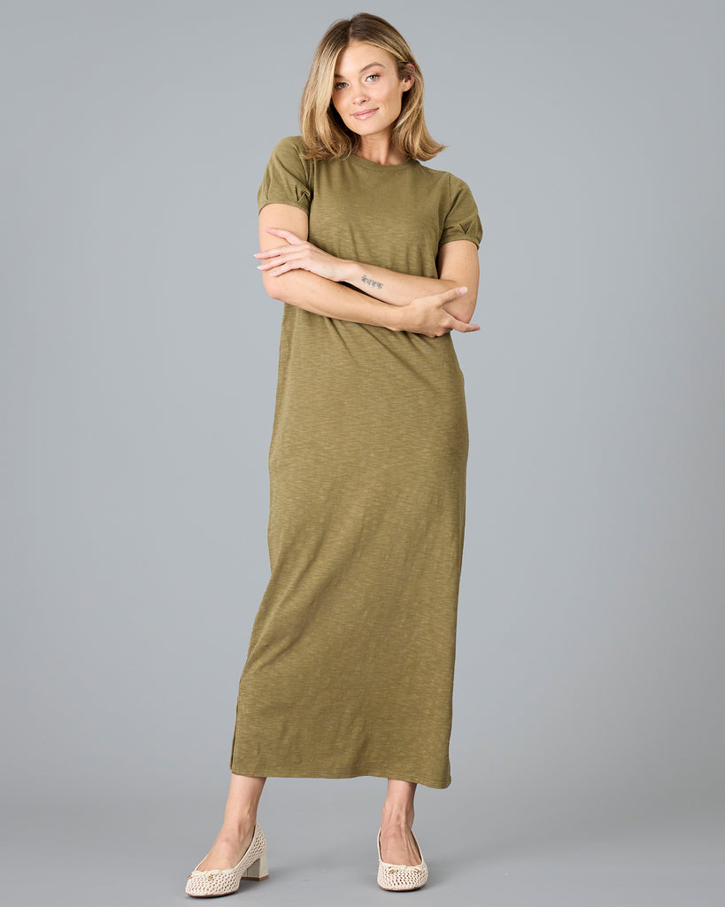 Woman in a short sleeve olive green sheath dress