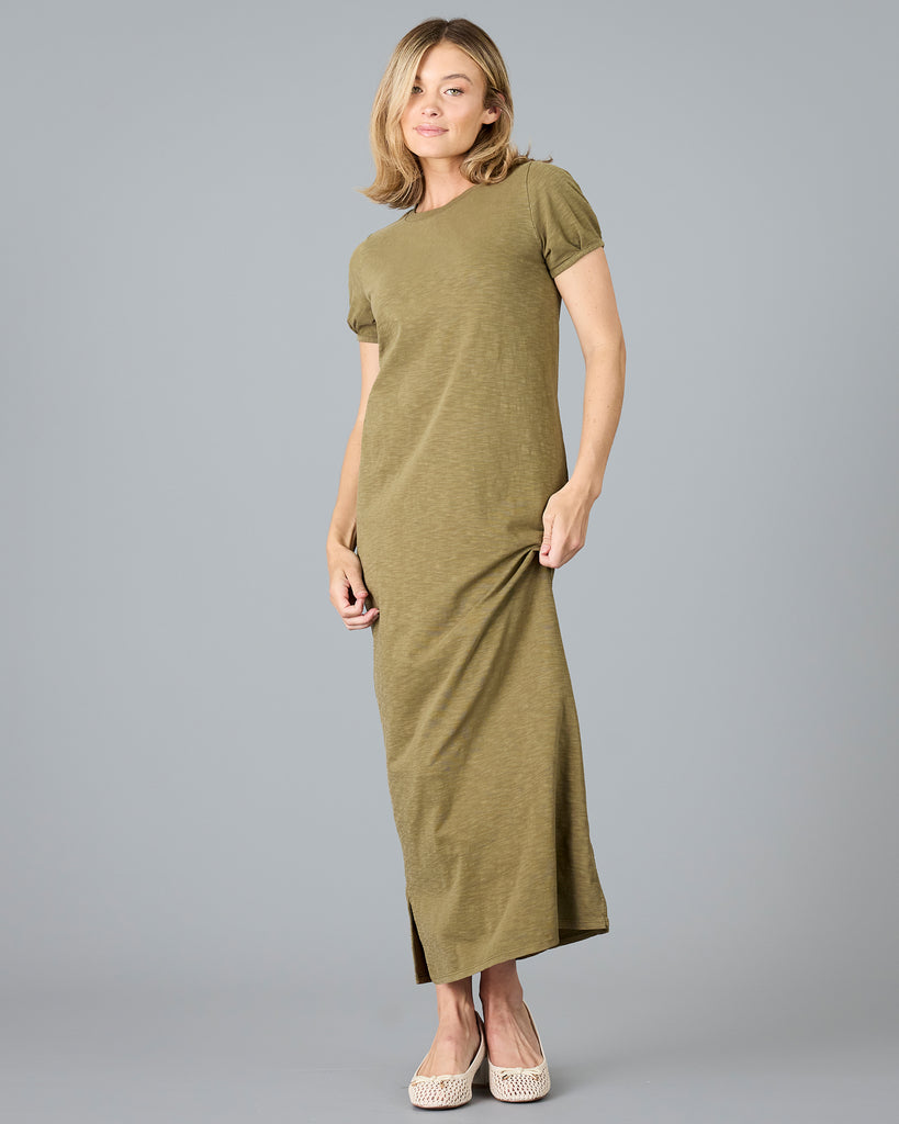 Woman in a short sleeve olive green sheath dress