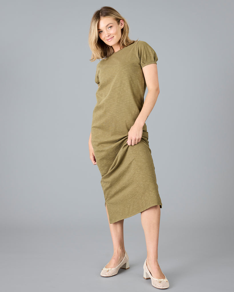 Woman in a short sleeve olive green sheath dress