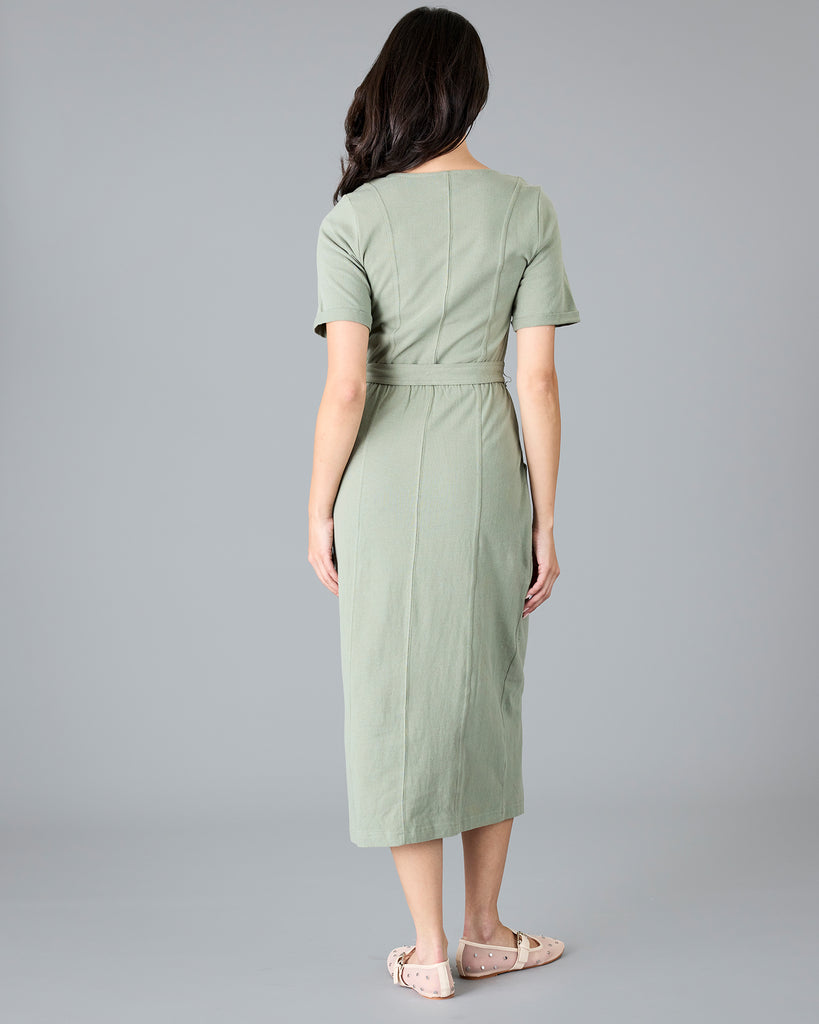 Woman in a green short sleeve dress with tie around waist