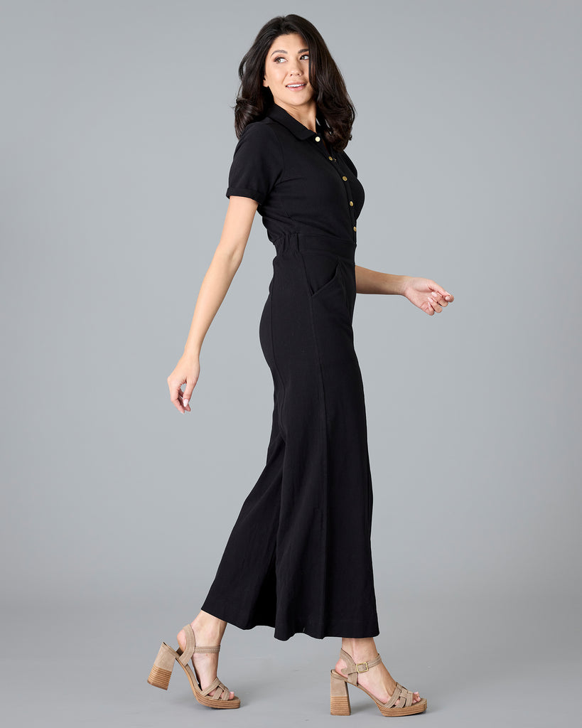 Woman in a black, short sleeve jumpsuit