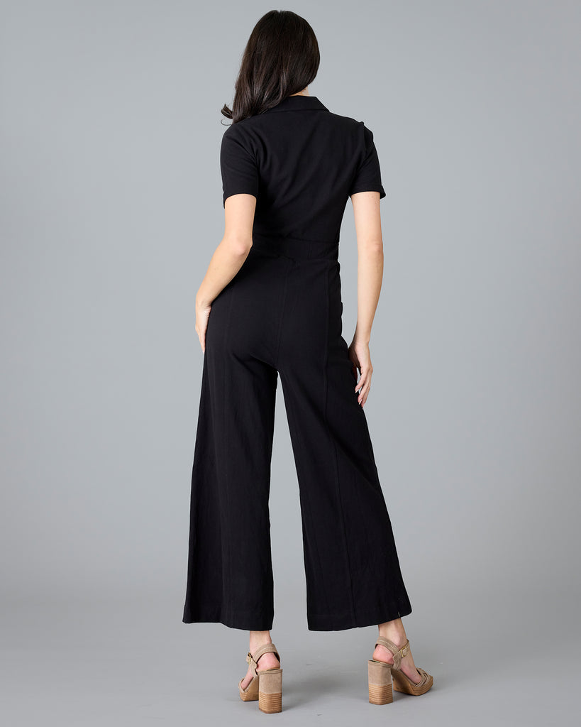 Woman in a black, short sleeve jumpsuit