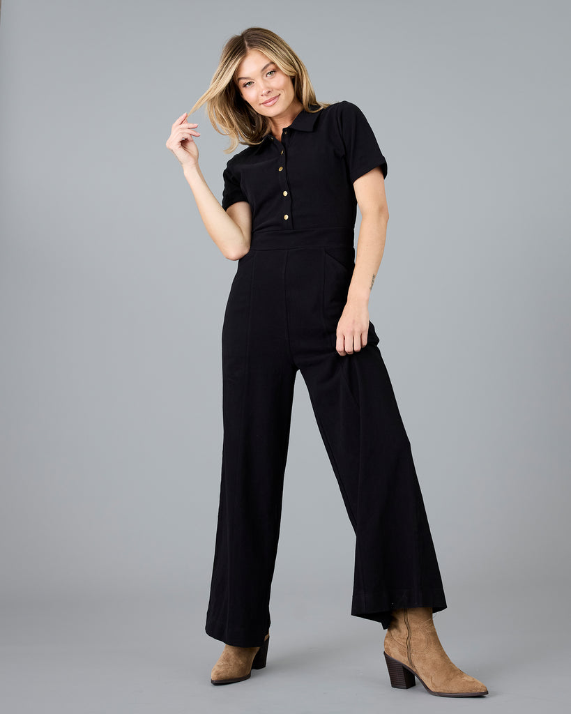 Woman in a black, short sleeve jumpsuit