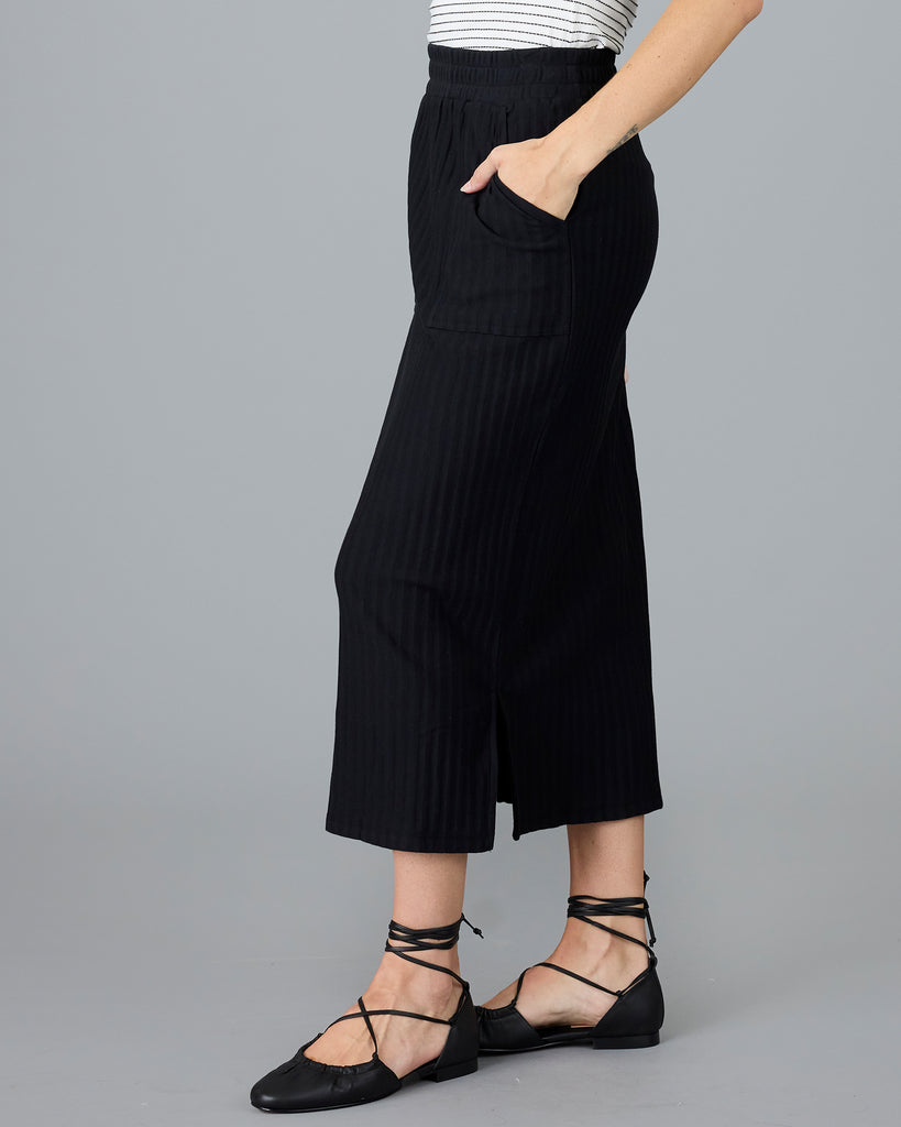 Woman in a black ribbed midi skirt