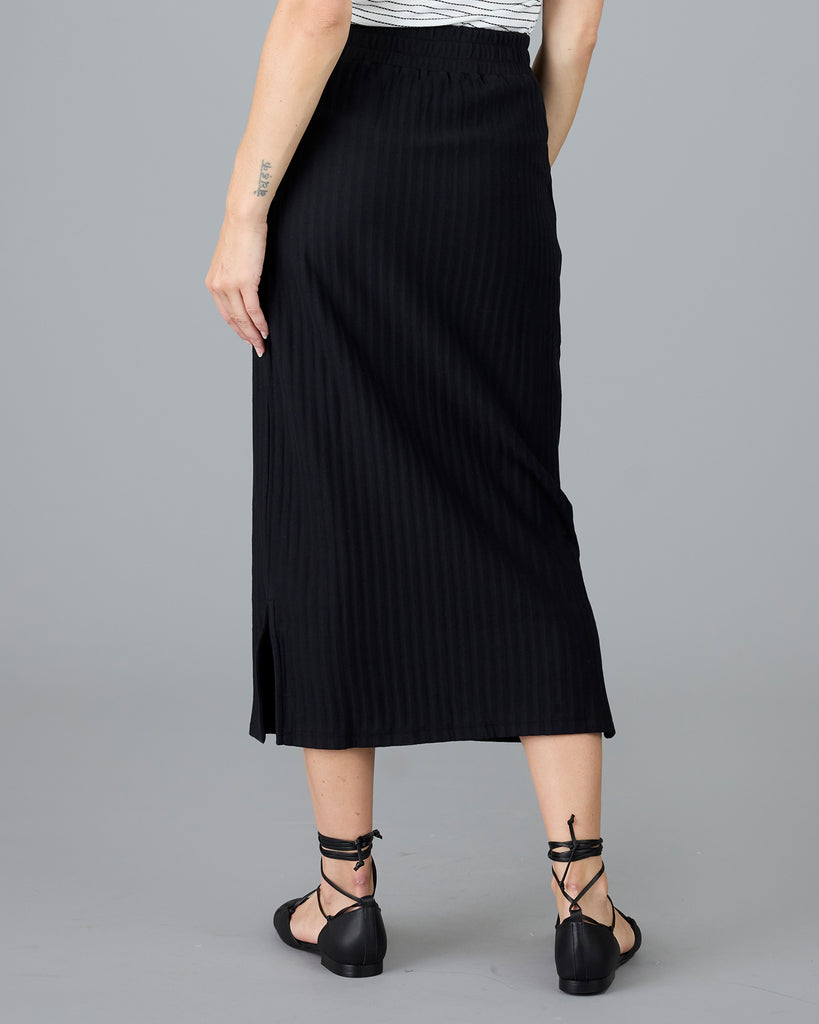 Woman in a black ribbed midi skirt