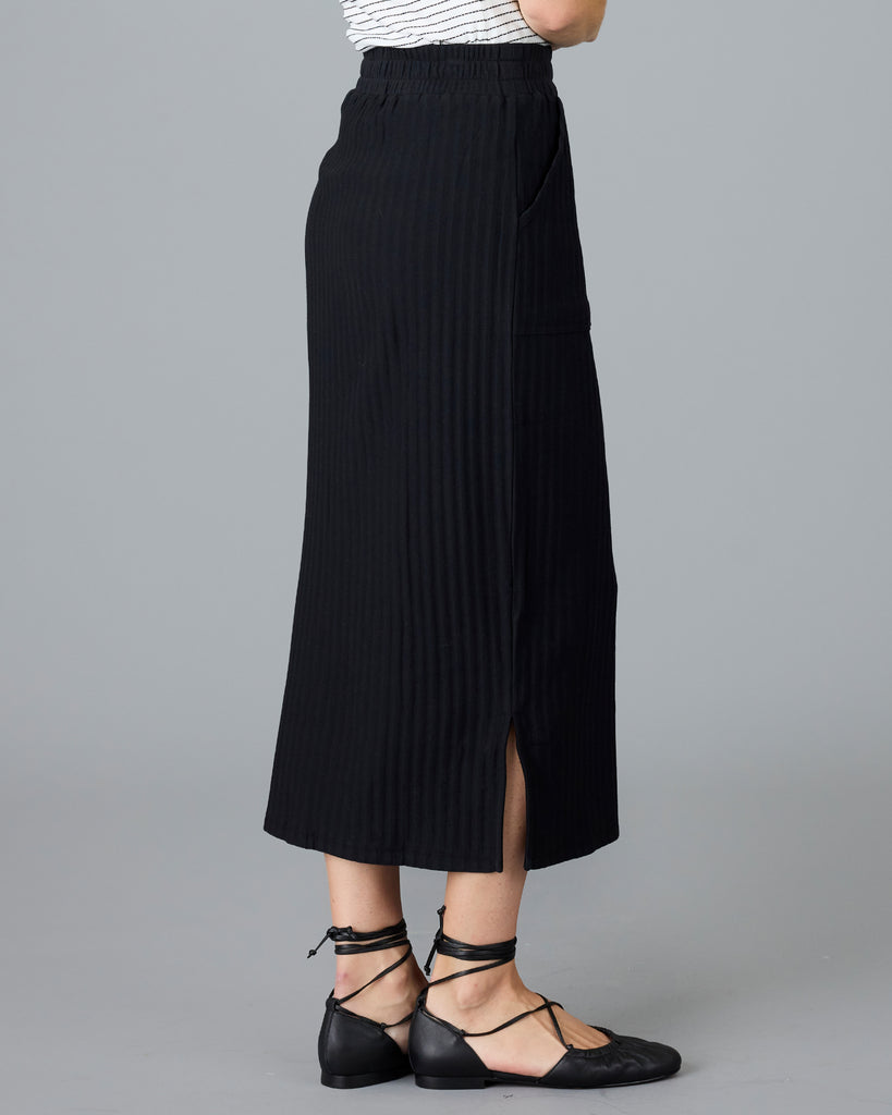 Woman in a black ribbed midi skirt