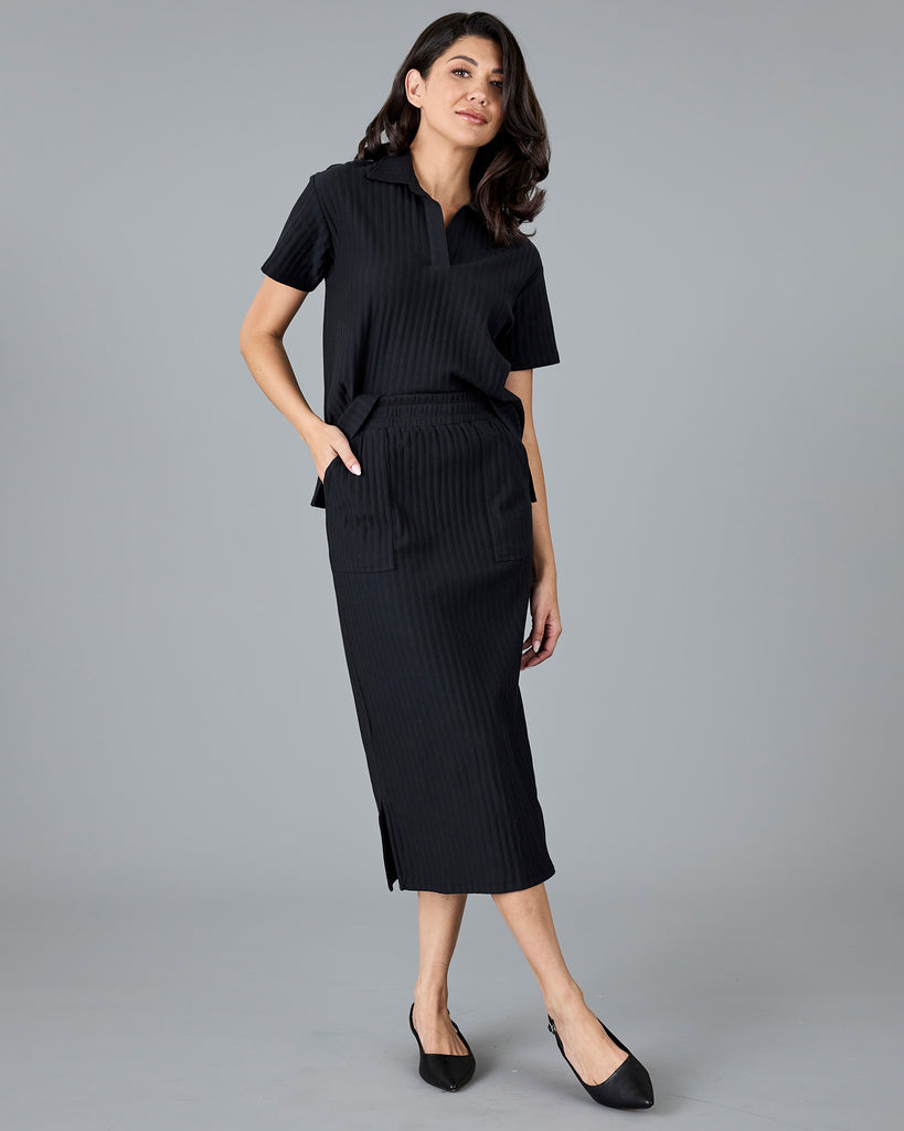 Woman in a black ribbed midi skirt