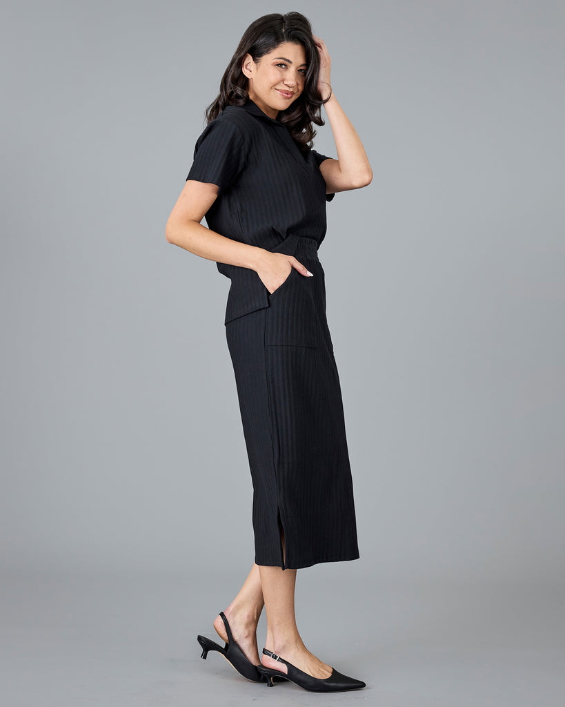 Woman in a black ribbed midi skirt