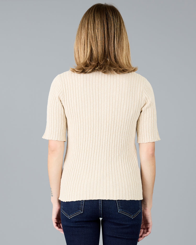 Woman in a beige, short sleeved ribbed cardigan