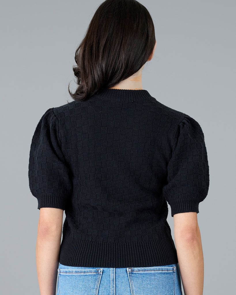 Woman in a short sleeve black sweater