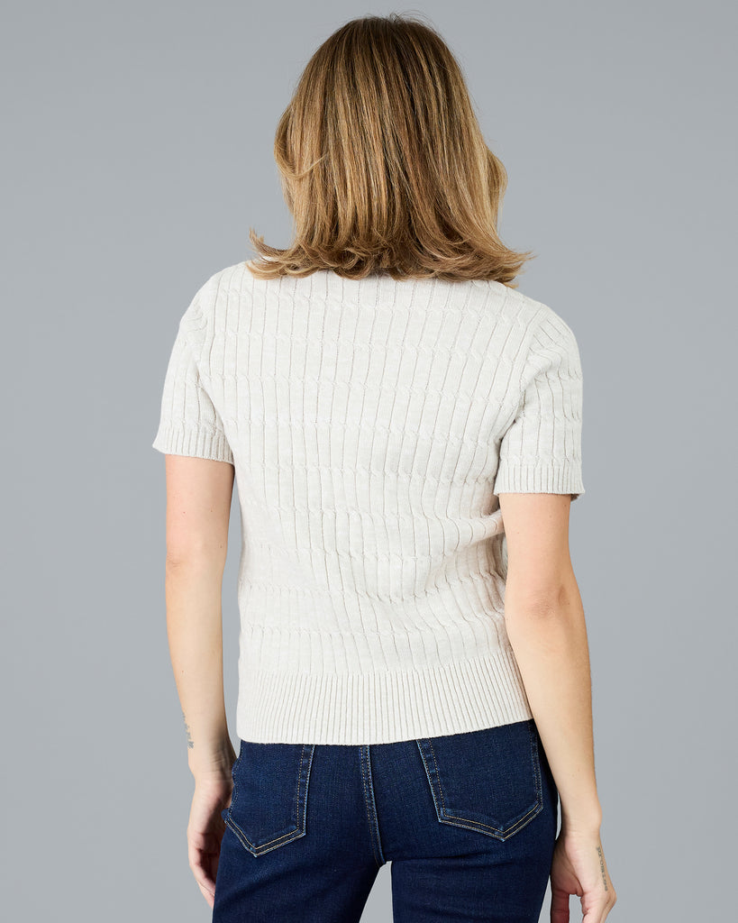 Woman in a short sleeve grey/beige sweater