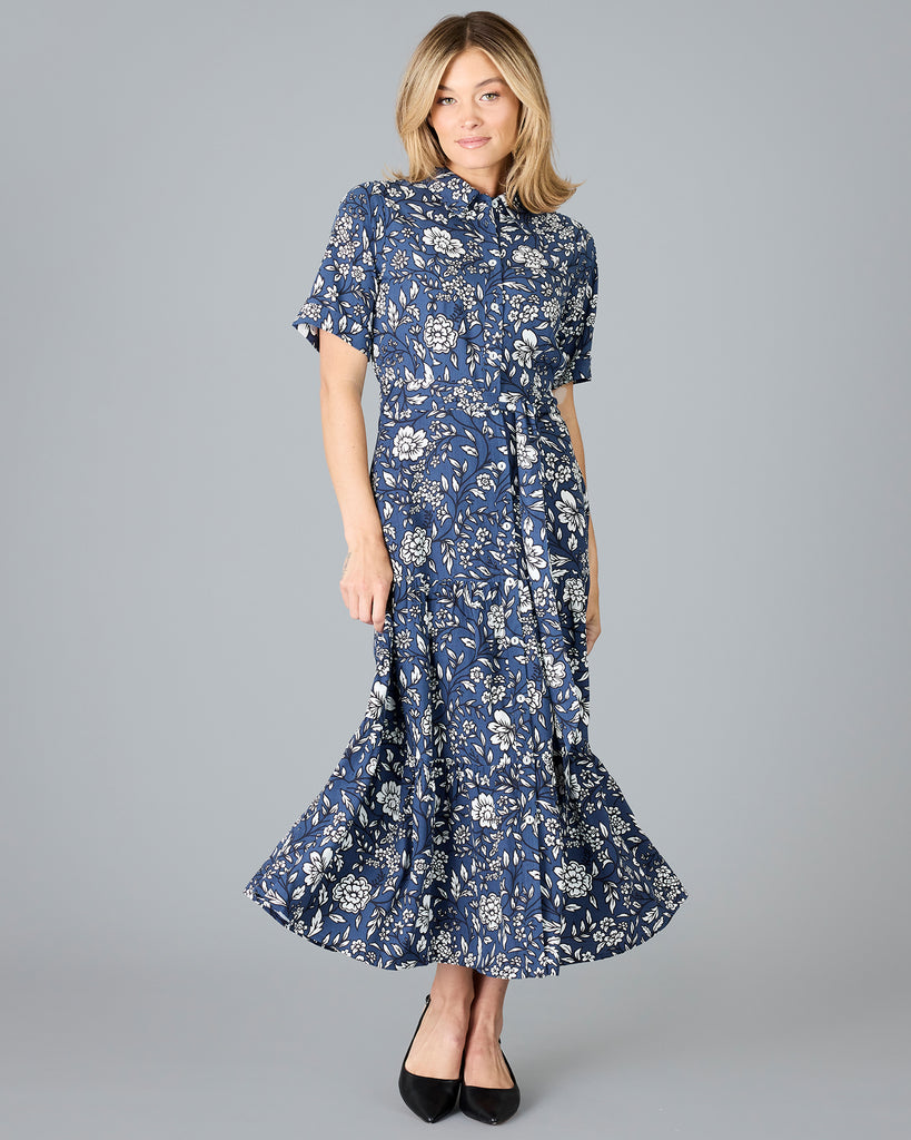 Woman in a blue and white floral print, short sleeve, buttondown dress