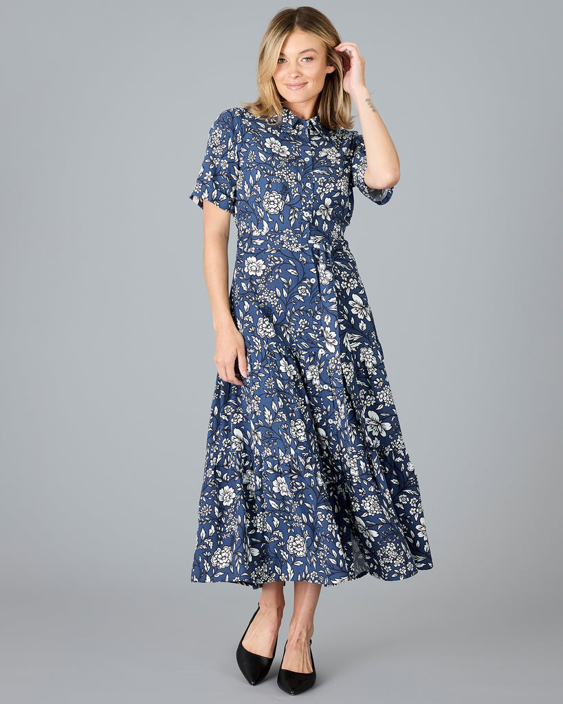 Woman in a blue and white floral print, short sleeve, buttondown dress