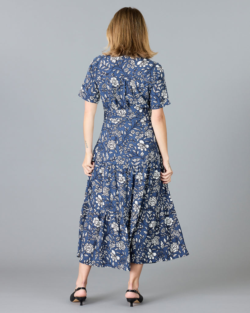 Woman in a blue and white floral print, short sleeve, buttondown dress