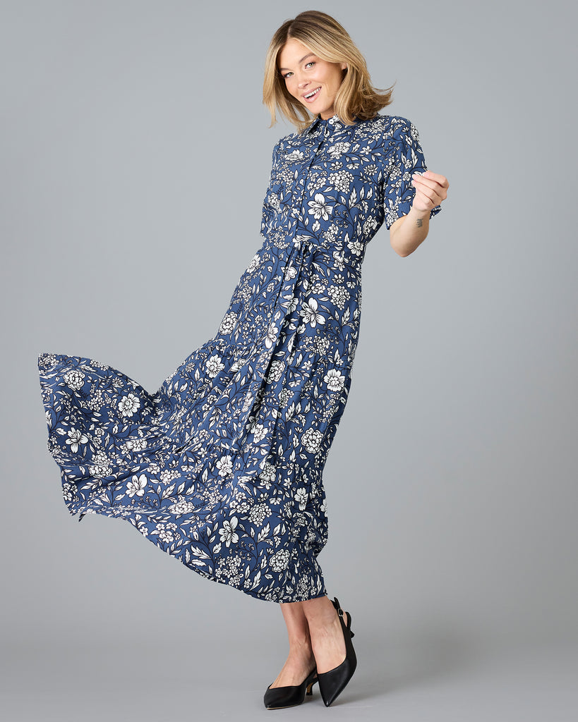 Woman in a blue and white floral print, short sleeve, buttondown dress