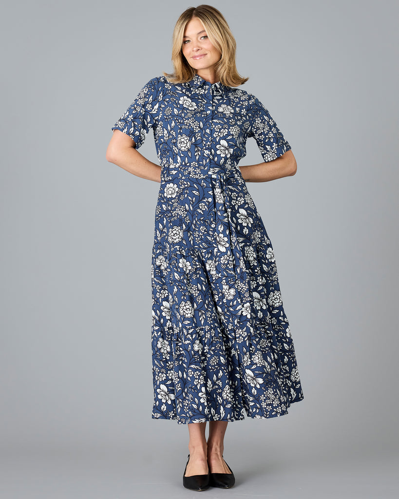 Woman in a blue and white floral print, short sleeve, buttondown dress