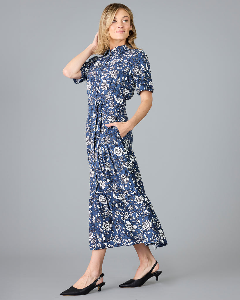 Woman in a blue and white floral print, short sleeve, buttondown dress