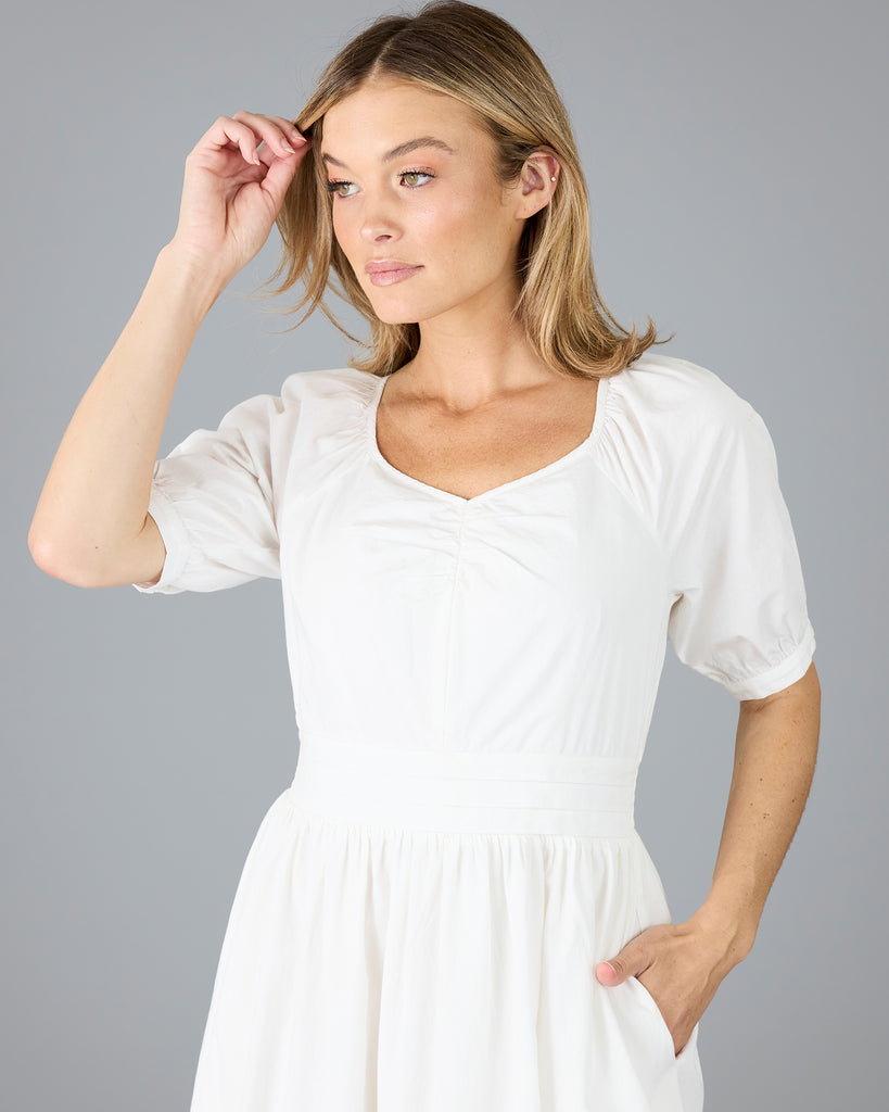 Woman in a white short sleeve v-neck dress