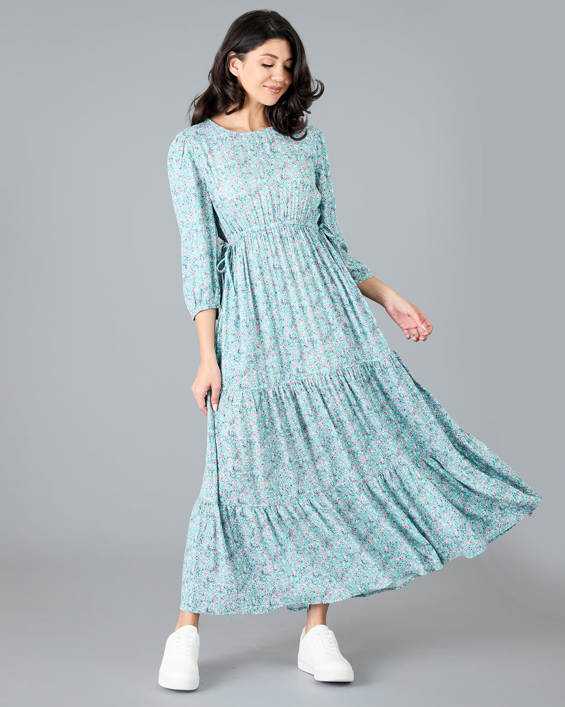 Woman in a blue floral print, long sleeve maxi dress