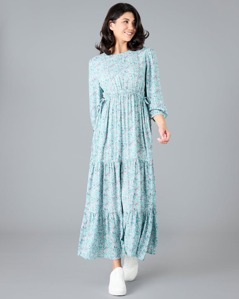 Woman in a blue floral print, long sleeve maxi dress