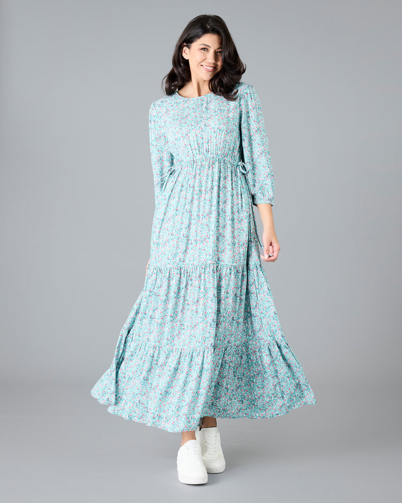 Woman in a blue floral print, long sleeve maxi dress