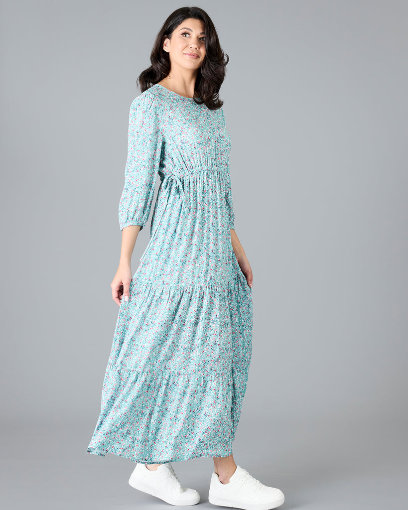 Woman in a blue floral print, long sleeve maxi dress