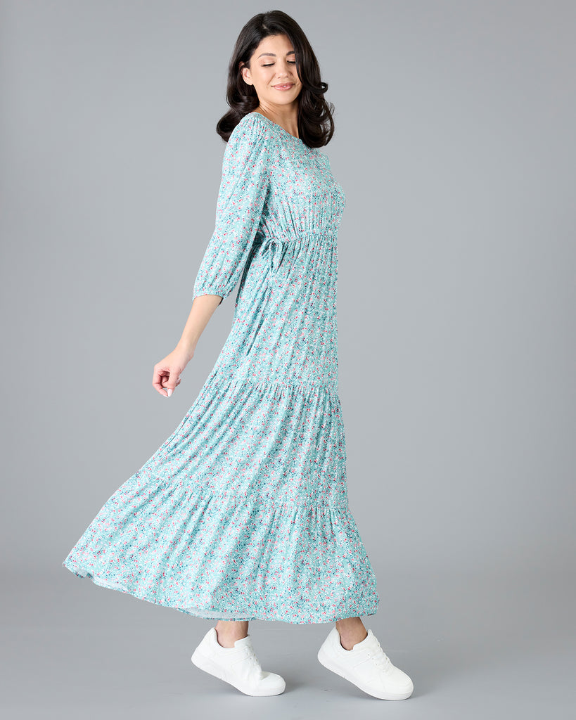 Woman in a blue floral print, long sleeve maxi dress