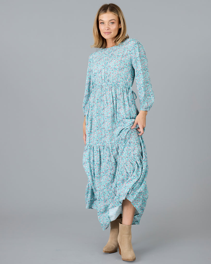 Woman in a blue floral print, long sleeve maxi dress