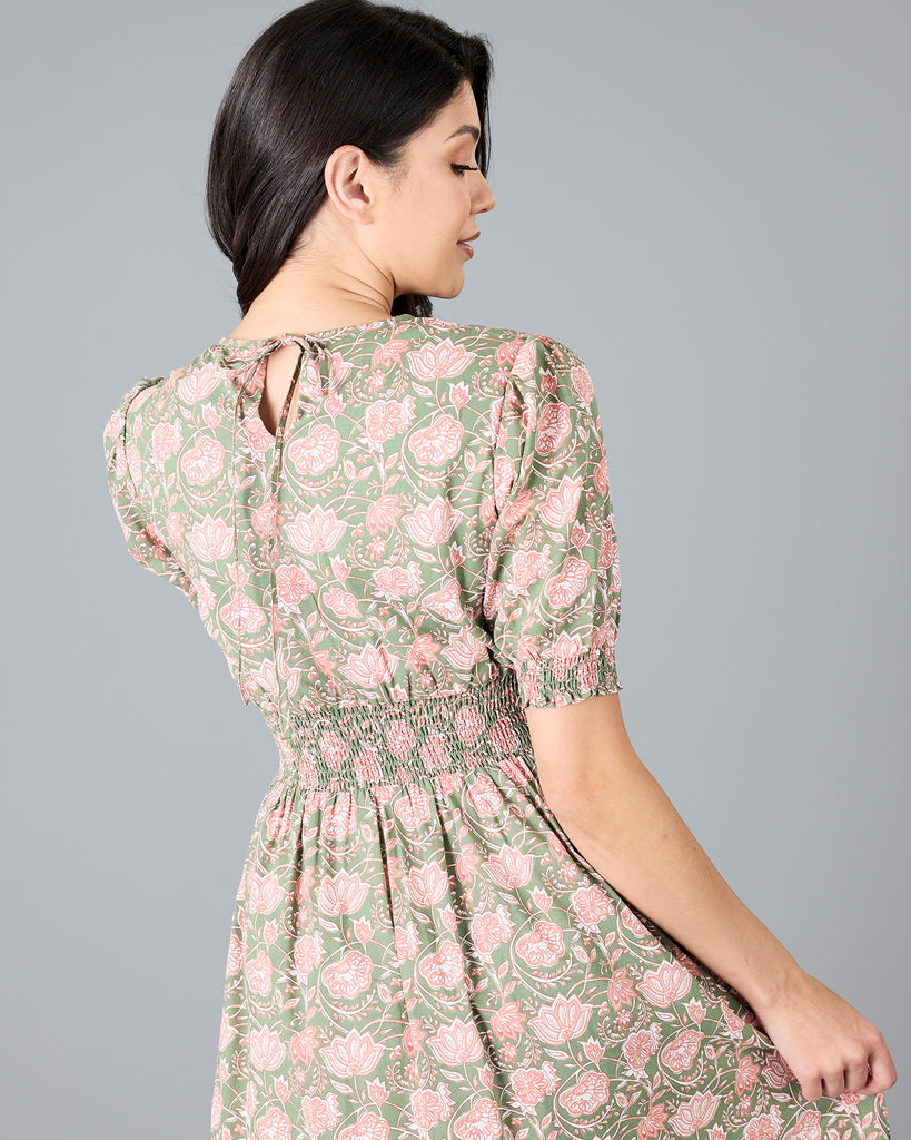 Woman in a green and pink paisley print, short sleeve midi dress