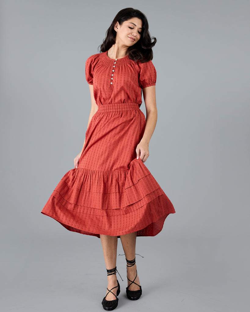 Woman in a midi length orange skirt